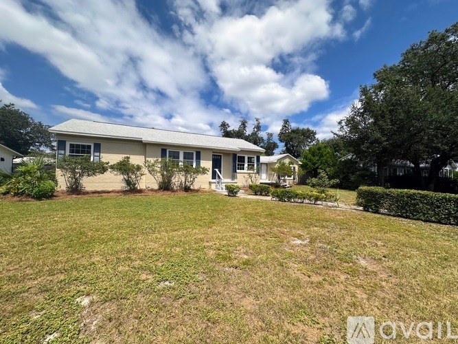 A house with a white roof and a green lawn in front.