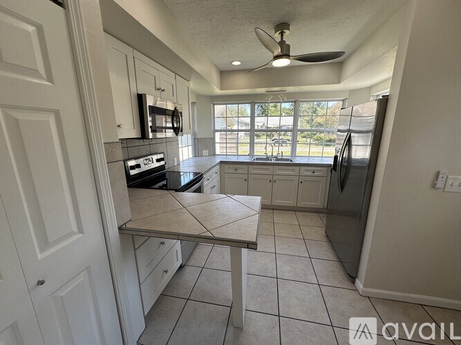 A kitchen with a table and a refrigerator.