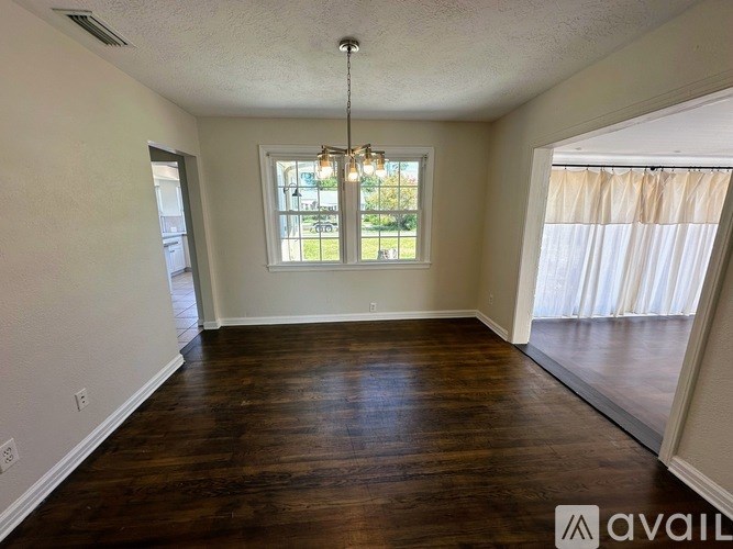 A room with wooden floors and a window with a view of the outside.