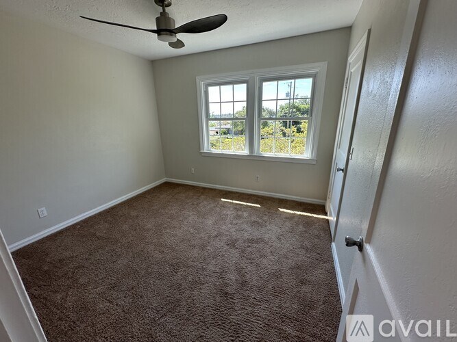 A room with a ceiling fan and a window.