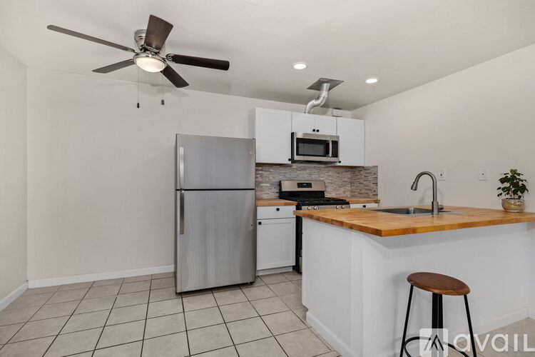 A kitchen with a refrigerator, microwave, and oven.