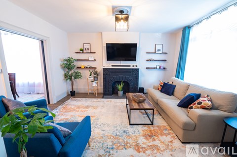 A living room with a blue couch and a fireplace.