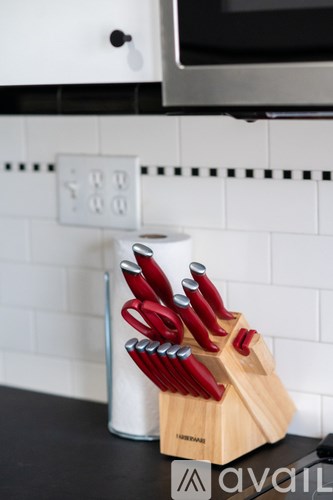 A set of knives is placed in a holder on a counter.