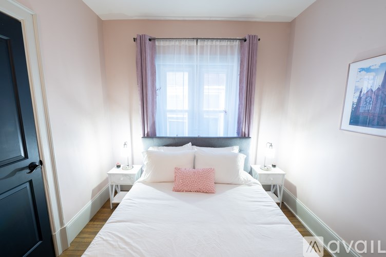 A bedroom with a large bed and two nightstands.