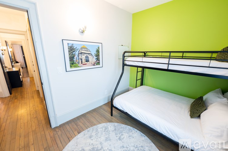A bedroom with a bunk bed and a picture of a building on the wall.