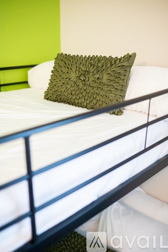 A pillow with a leaf pattern is on a white bed.