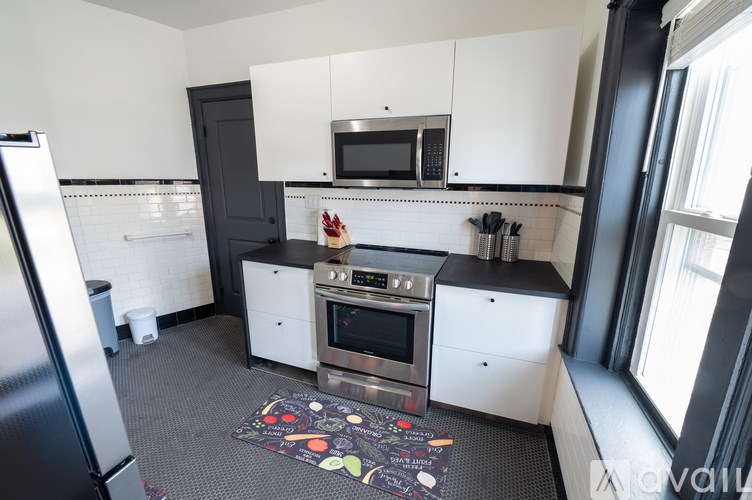 A kitchen with a refrigerator, oven, and microwave.
