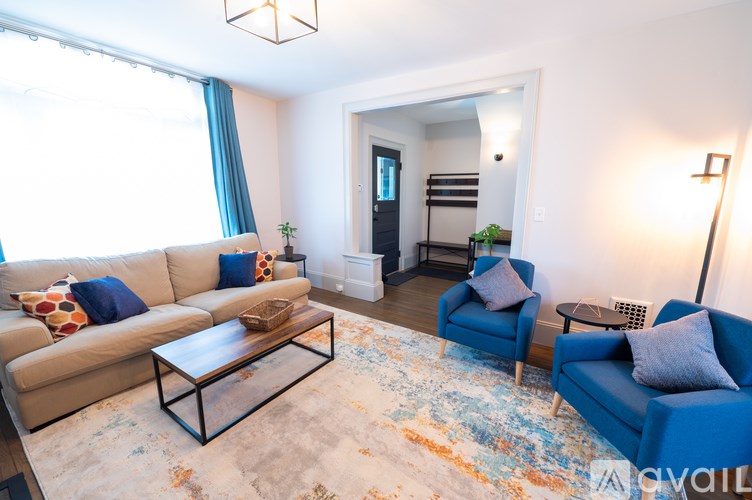 A living room with a beige couch, blue armchair, and a coffee table.