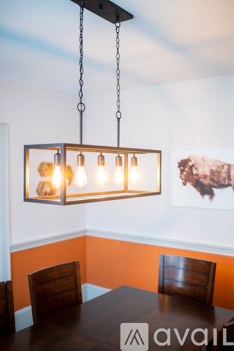 A chandelier with six lights hangs from the ceiling above a dining table.