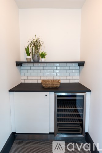 A kitchen with a black countertop and a white cabinet.