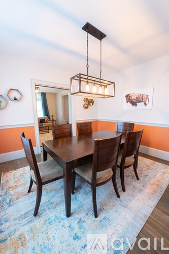 A dining room with a table and chairs.