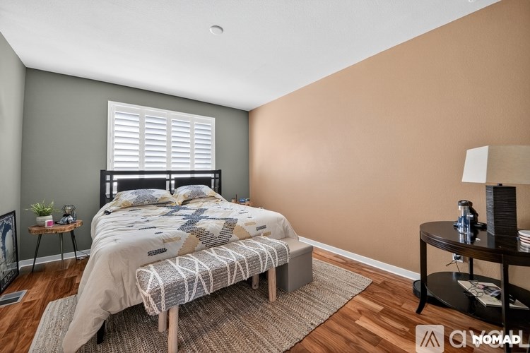 A bedroom with a bed, nightstand, and lamp.