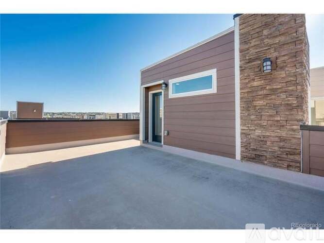 A modern house with a brown exterior and a stone pillar.