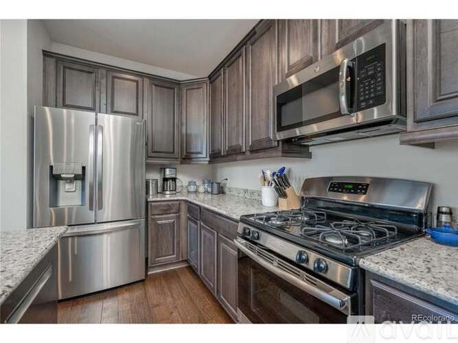 A kitchen with a stainless steel refrigerator, microwave, and stainless steel oven.