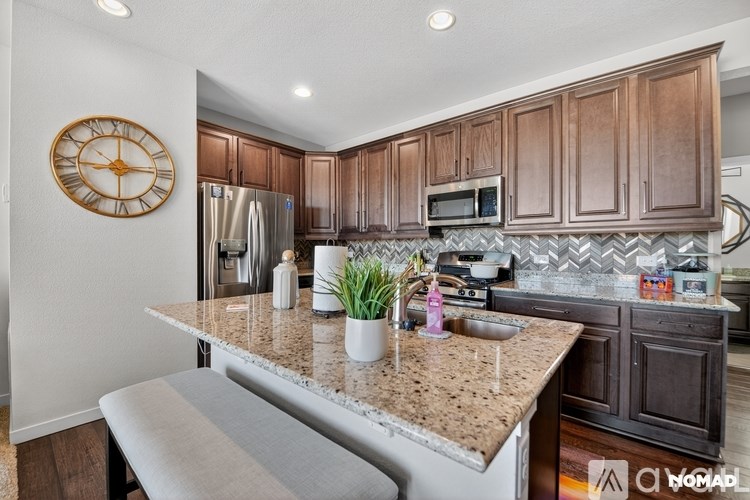 A bedroom with a bed, nightstand, and a window with blinds.