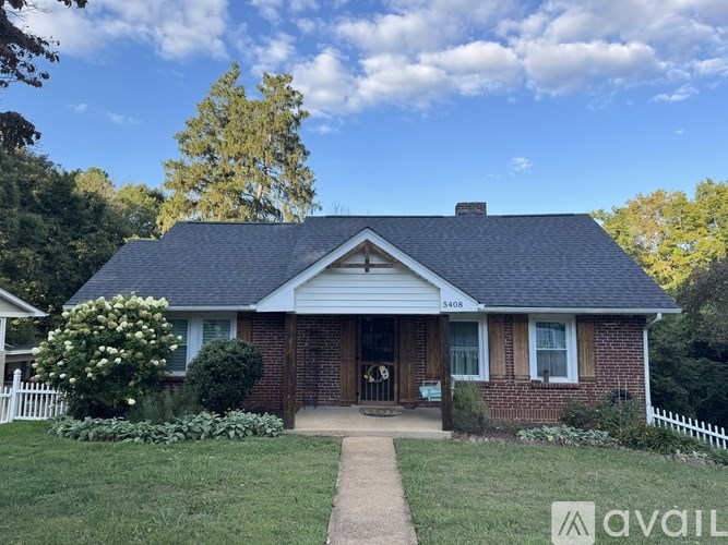 A house with a white picket fence in front of it.