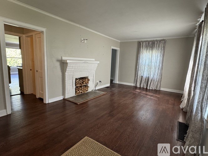 A living room with a fireplace and wood flooring.