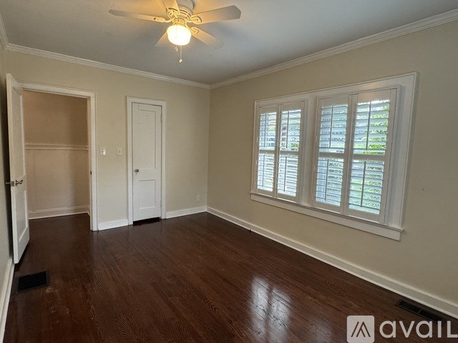 A room with a ceiling fan and wooden flooring.