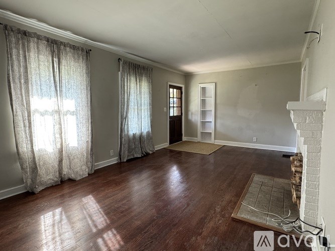 A living room with a fireplace and a rug on the floor.