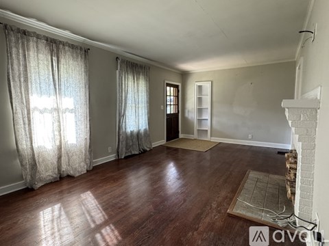 A living room with a fireplace and a rug on the floor.