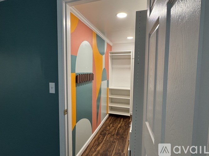 A hallway with a blue wall and a white door.