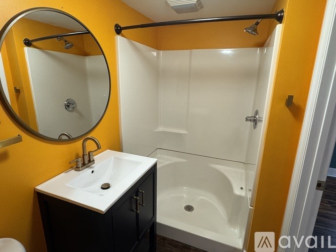 A bathroom with a sink, mirror, and bathtub.