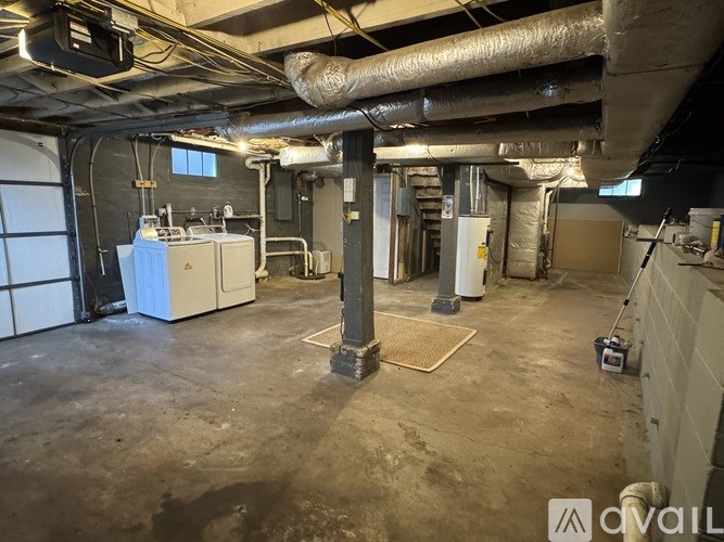 A large industrial room with a white unit and a tall column.