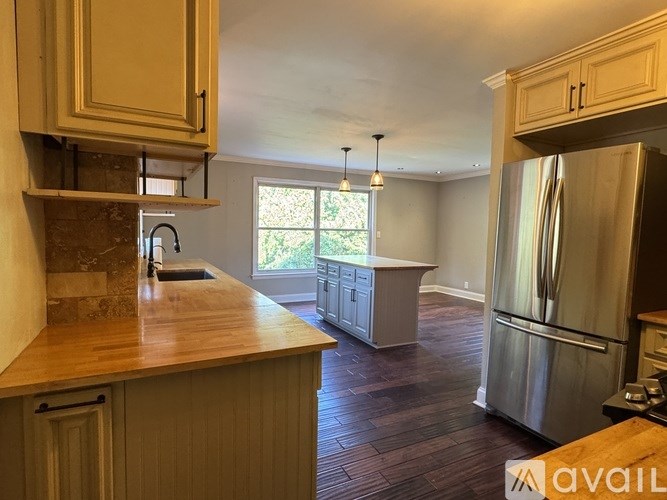 A kitchen with wooden cabinets and a stainless steel refrigerator.