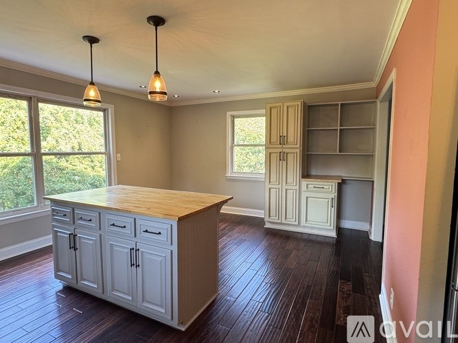 A kitchen with a wooden counter top and cabinets.