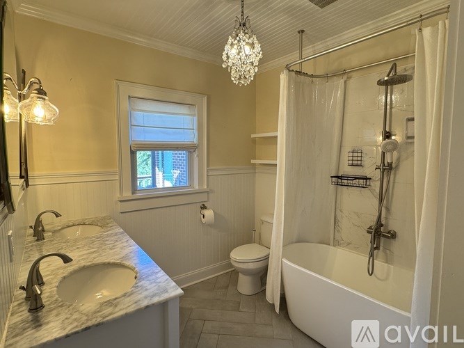 A bathroom with a marble countertop and a chandelier.