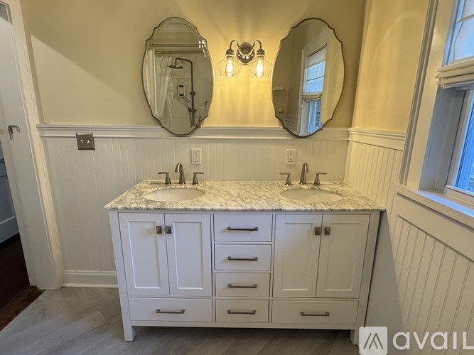 A bathroom vanity with a marble countertop and two sinks.