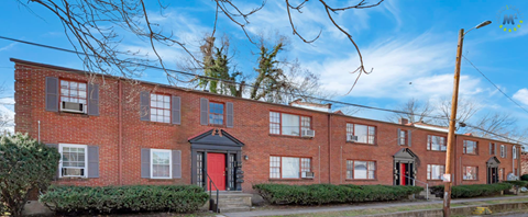A row of red brick houses with a black door and windows.