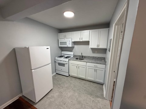 A kitchen with white appliances and cabinets.