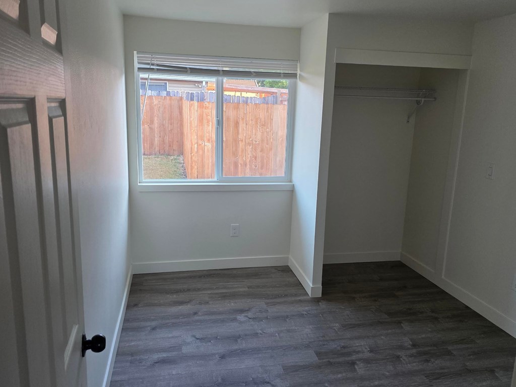 A room with a window and a wooden fence visible outside.