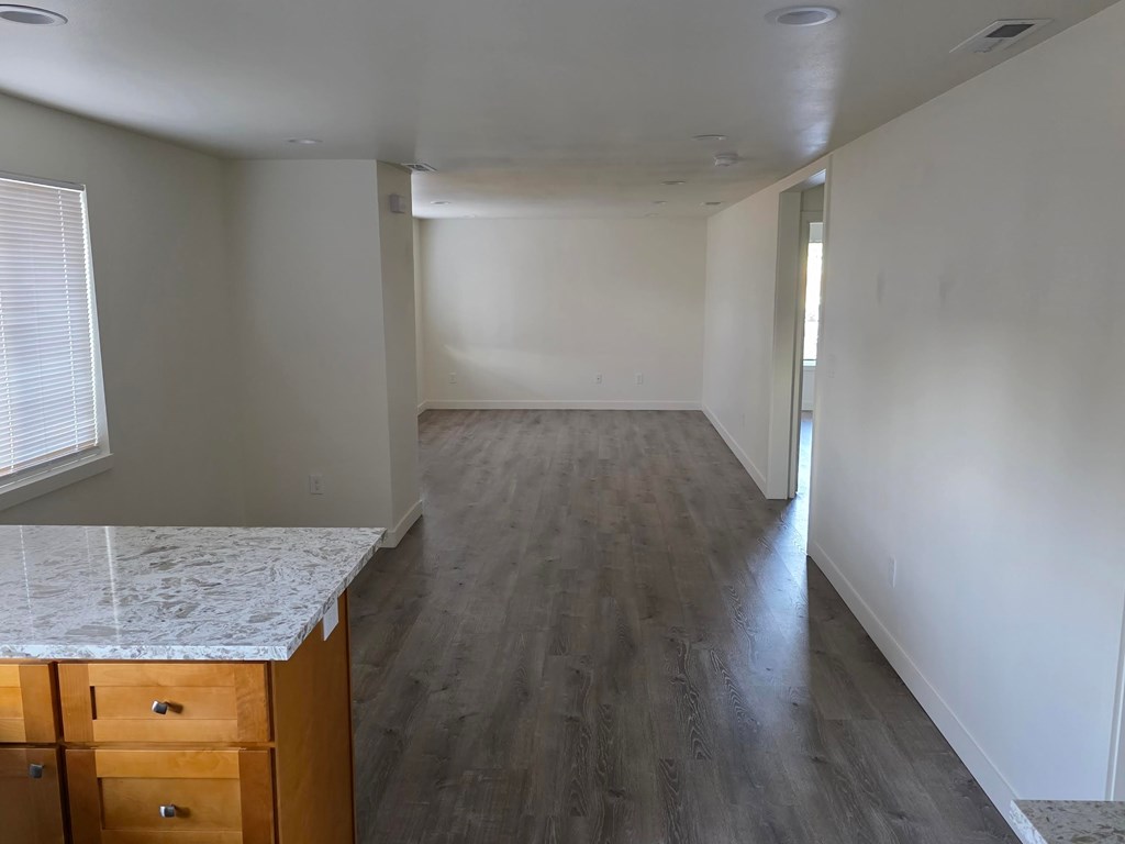 A room with a marble countertop and wooden drawers.
