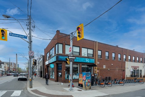 A street view with a traffic light and a building with a blue sign.