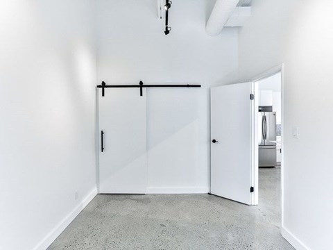 A white room with a sliding door and a light fixture on the ceiling.