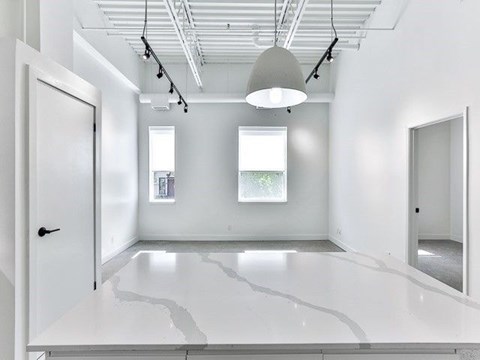 A white room with a large white floor and a white ceiling with a light hanging from it.