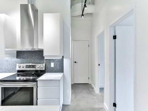 A modern kitchen with a stove top oven and a range hood.