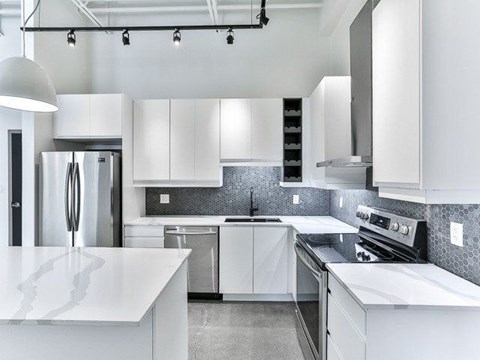 A modern kitchen with white cabinets and stainless steel appliances.