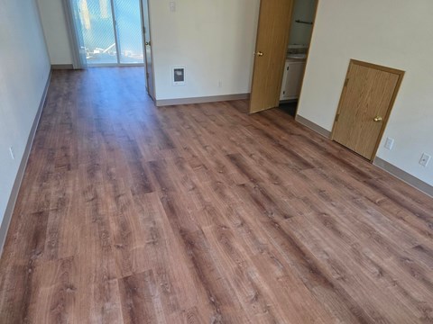 A room with wooden flooring and a sliding glass door.