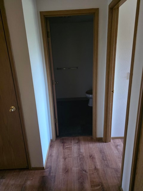 A dark room with a doorway leading to another room.