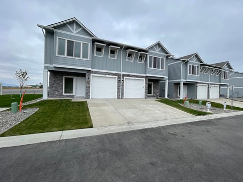 A grey house with a white garage door in front.