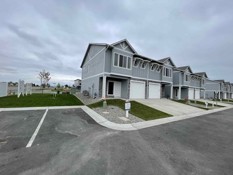 A row of houses with a driveway in front.