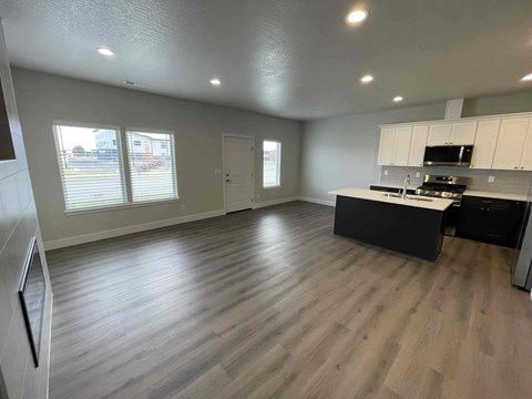A spacious kitchen with a black countertop and white cabinets.