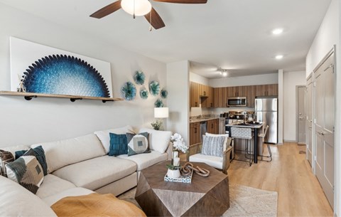 A living room with a white couch and a ceiling fan.