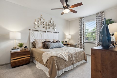 A bedroom with a large bed and a ceiling fan.