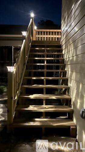 A wooden staircase with a light on the side.