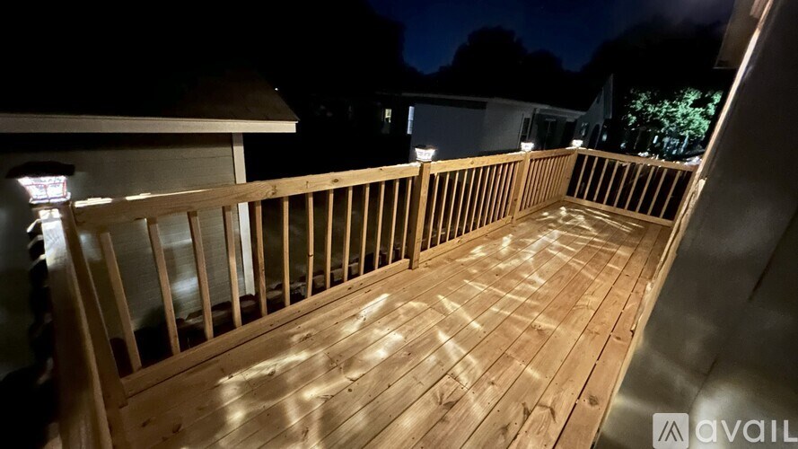 A wooden deck is lit up at night.