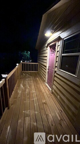 A deck with a pink door and a lit up lamp.